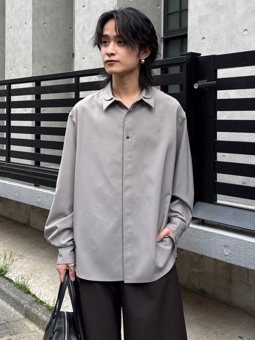 グレー系のシャツ/ブラウス、グレー系のスラックス、ブラック系のショルダーバッグを着用したメンズの春コーディネートの4枚目の写真