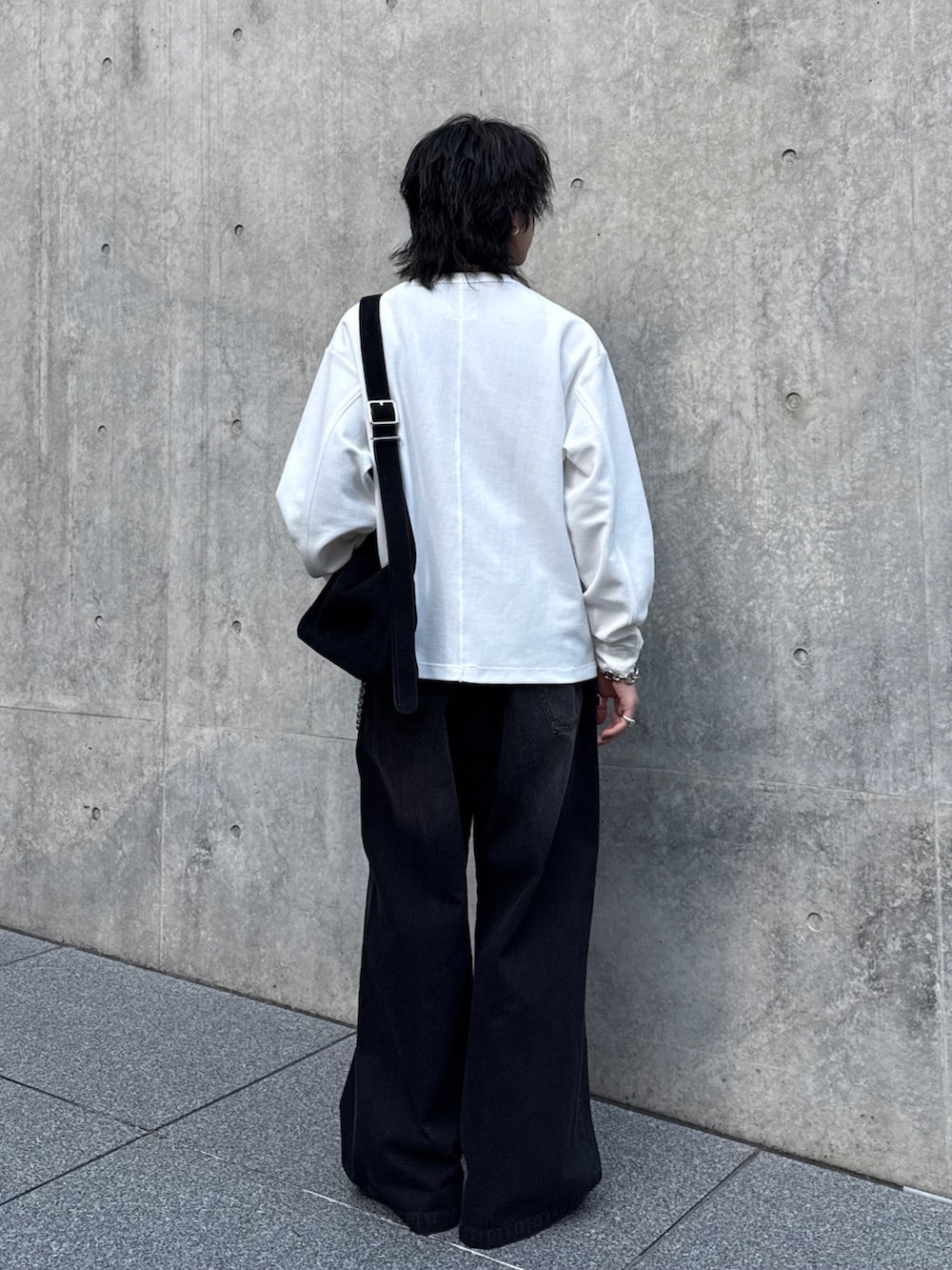 ホワイト系のTシャツ/カットソー、ブラック系のショルダーバッグ、ブラック系のデニムパンツを着用したメンズの春コーディネートの3枚目の写真