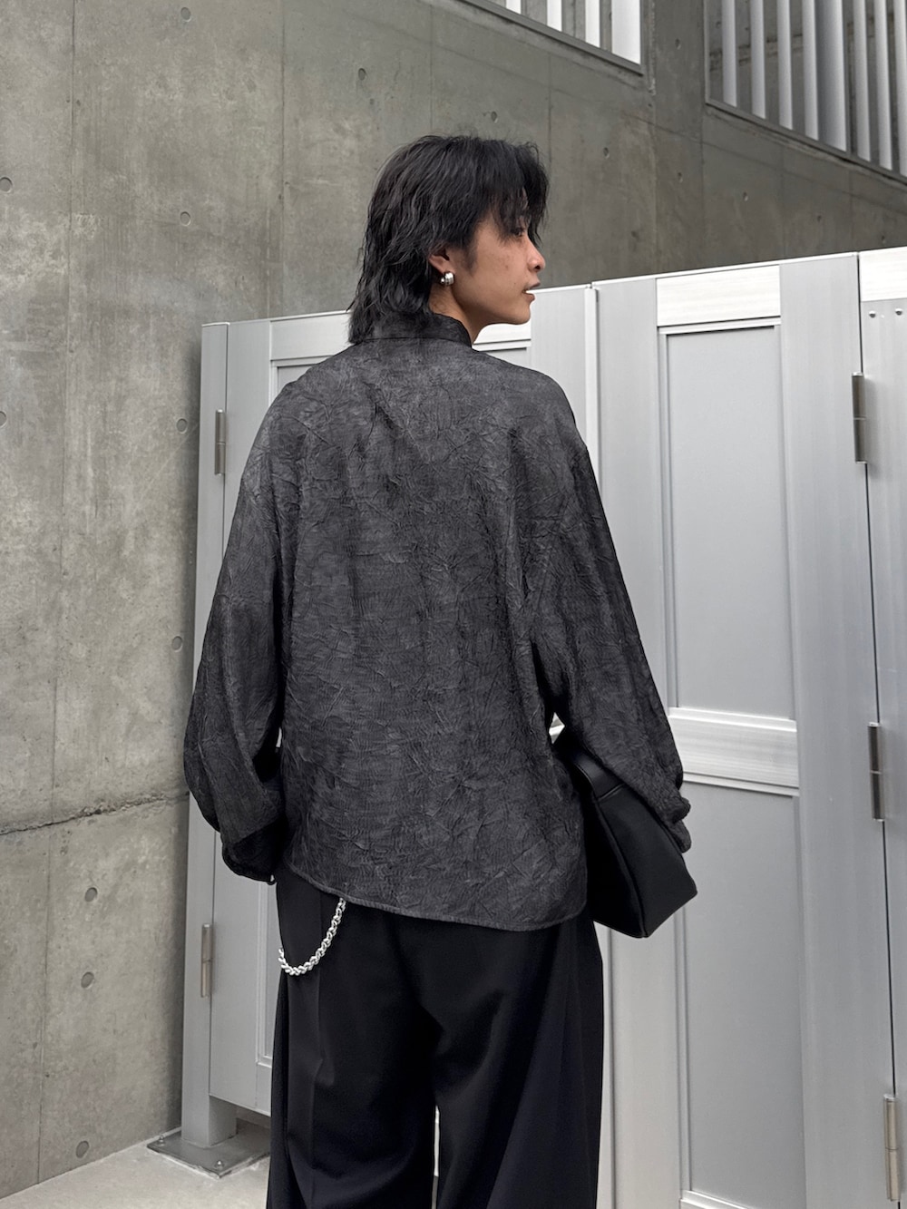 ブラック系のシャツ/ブラウス、ブラック系のスラックス、ブラック系のショルダーバッグを着用したメンズの春コーディネートの6枚目の写真