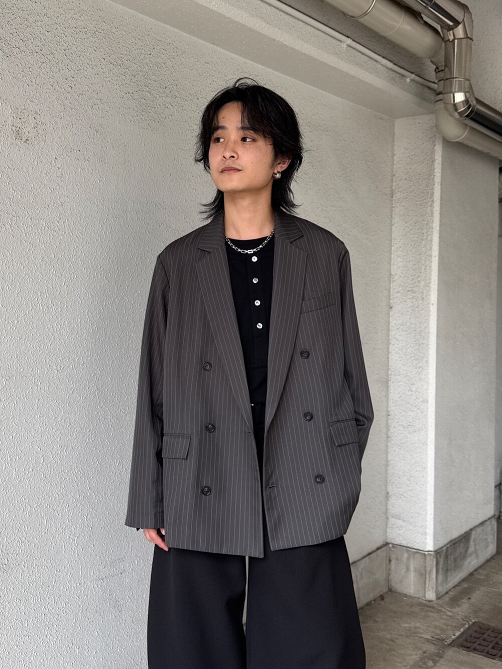 グレー系のテーラードジャケット、ブラック系のTシャツ/カットソー、ブラック系のスラックスを着用したメンズの春コーディネートの5枚目の写真