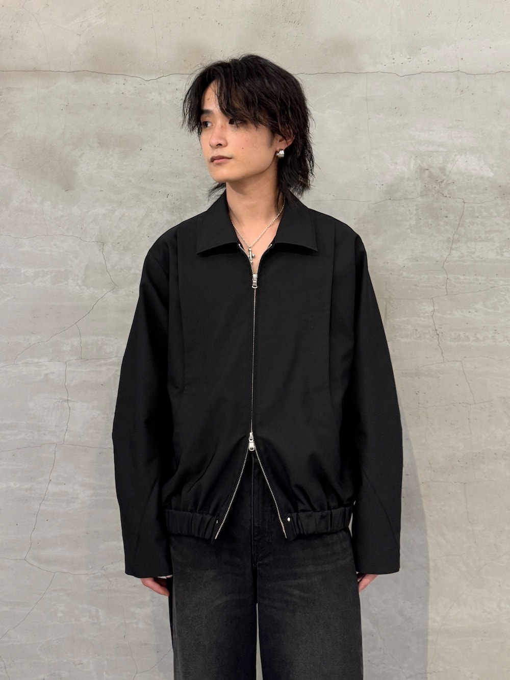 ブラック系のブルゾン、ブラック系のデニムパンツを着用したメンズの春コーディネートの4枚目の写真