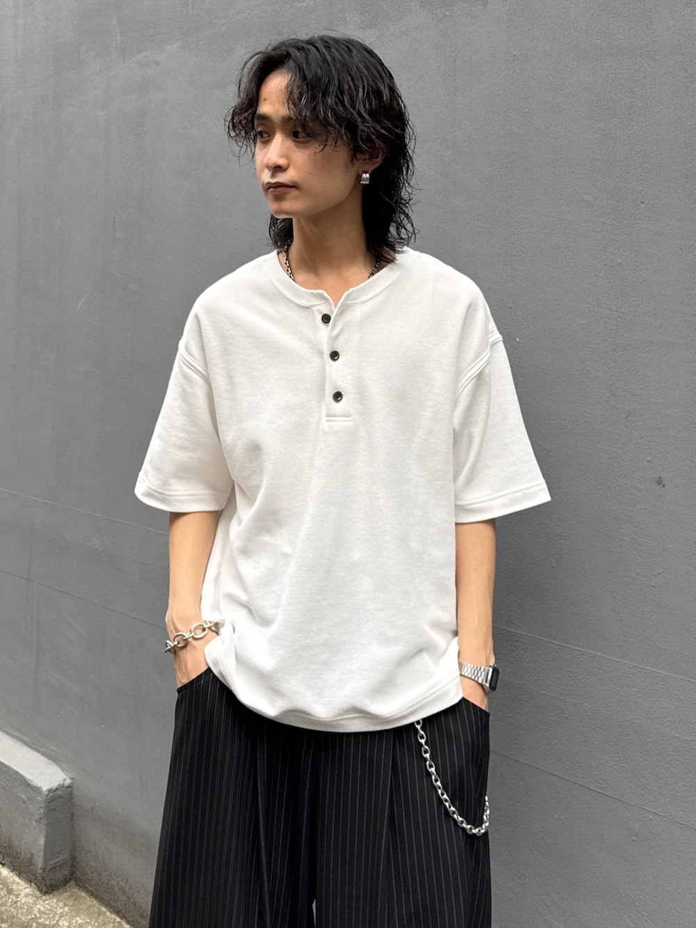 ホワイト系のTシャツ/カットソー、ブラック系のスラックス、シルバー系のウォレットチェーンを着用したメンズの夏コーディネートの4枚目の写真