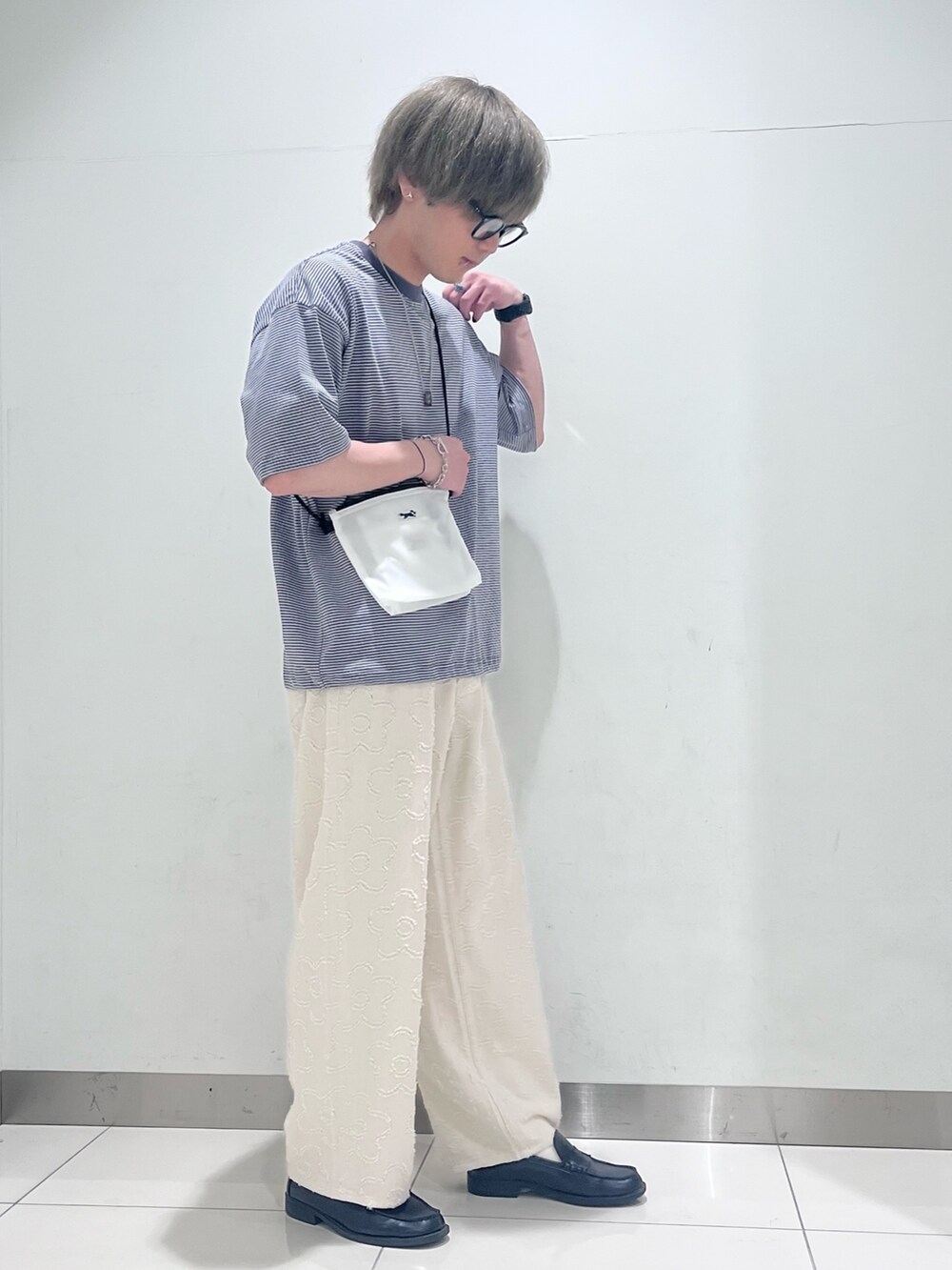 グレー系のTシャツ/カットソー、グリーン系のショルダーバッグ、ホワイト系のデニムパンツを着用したメンズの春コーディネートの4枚目の写真