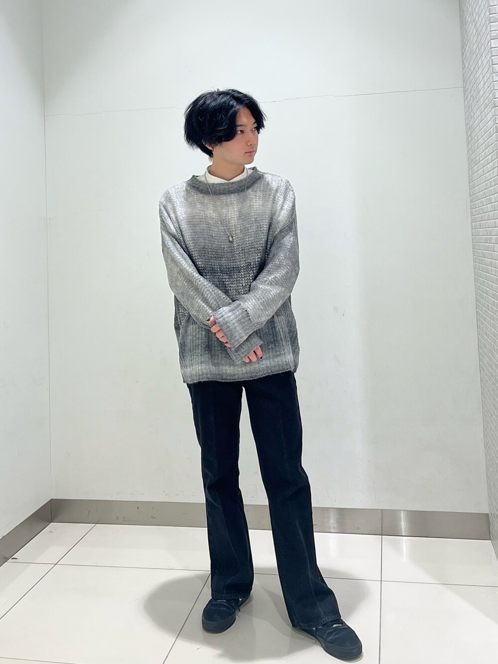 ホワイト系のシャツ/ブラウス、ブラック系のニット/セーター、ブラック系のスニーカーを着用したメンズの冬コーディネートの5枚目の写真