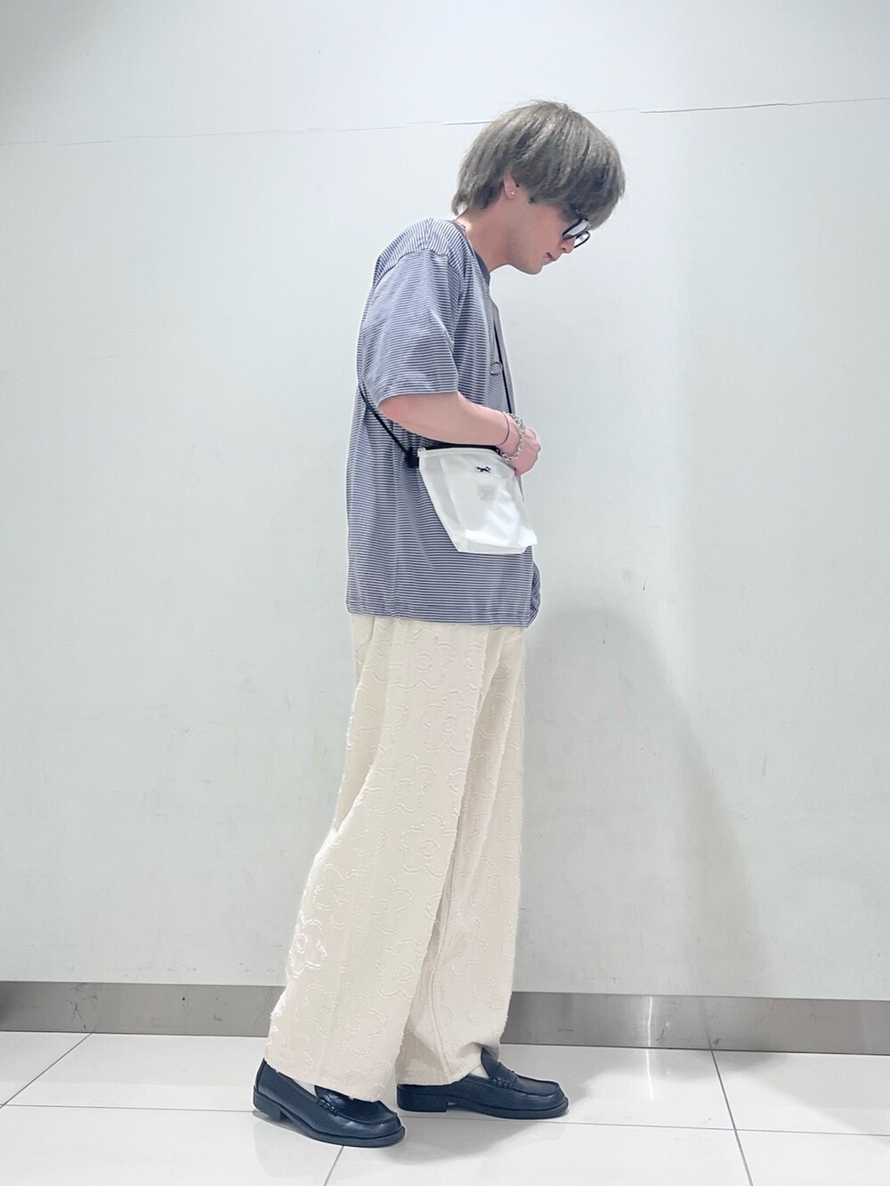 グレー系のTシャツ/カットソー、グリーン系のショルダーバッグ、ホワイト系のデニムパンツを着用したメンズの春コーディネートの3枚目の写真