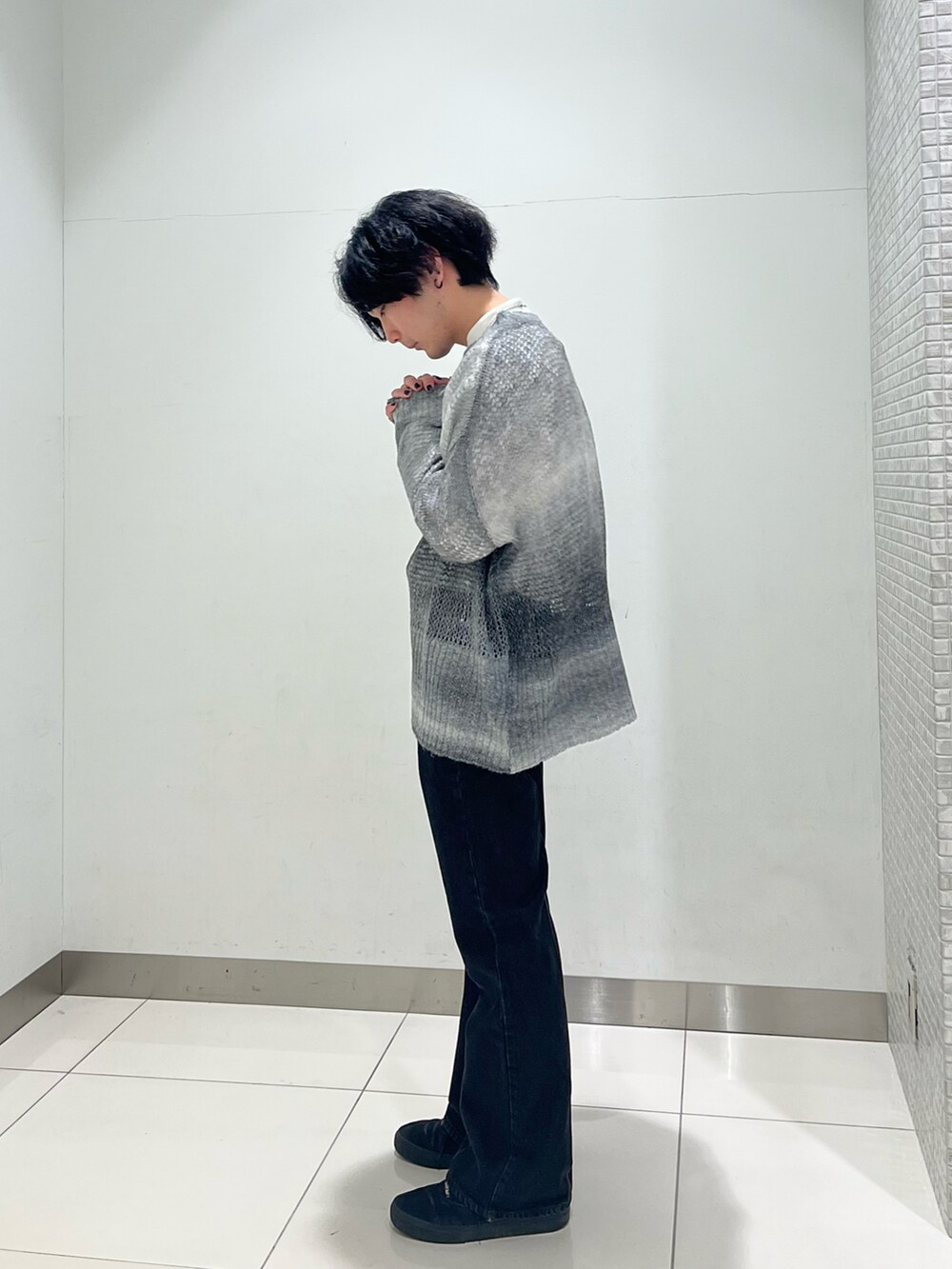 ホワイト系のシャツ/ブラウス、ブラック系のニット/セーター、ブラック系のスニーカーを着用したメンズの冬コーディネートの3枚目の写真