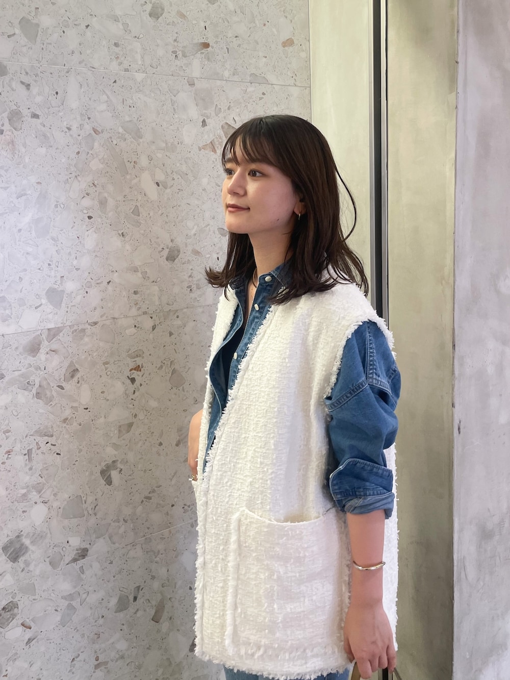 ホワイト系のベスト、ブルー系のシャツ/ブラウス、ブルー系のデニムパンツを着用したレディースの夏コーディネートの3枚目の写真