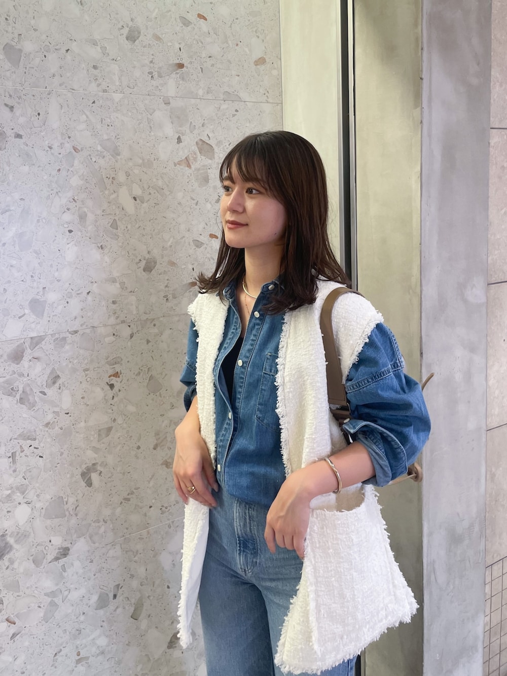 ホワイト系のベスト、ブルー系のシャツ/ブラウス、ブルー系のデニムパンツを着用したレディースの夏コーディネートの4枚目の写真