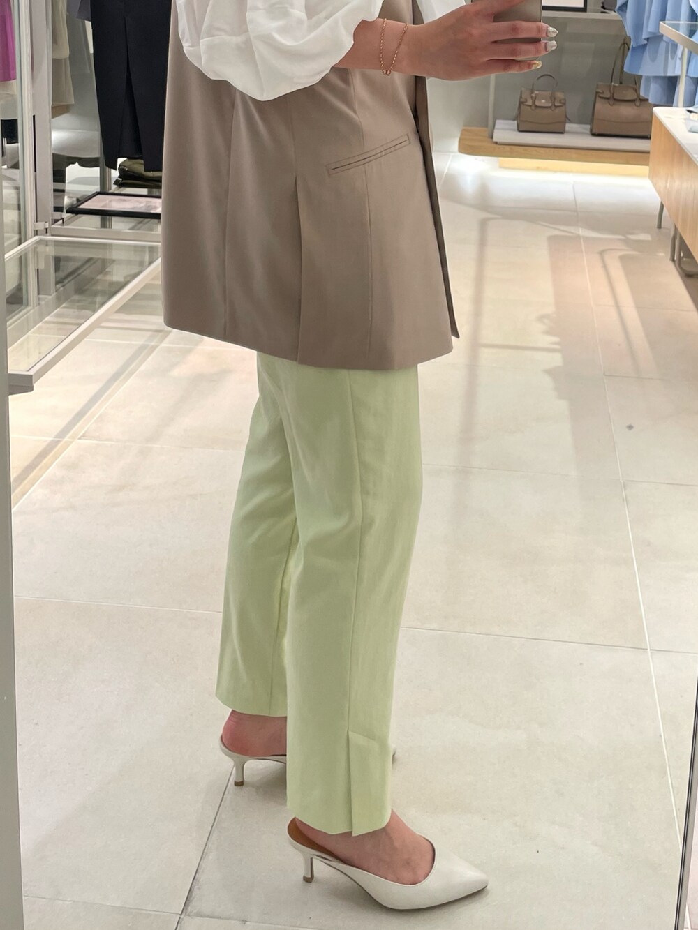 ベージュ系のベスト、ホワイト系のシャツ/ブラウス、グリーン系のその他パンツを着用したレディースの春コーディネートの5枚目の写真