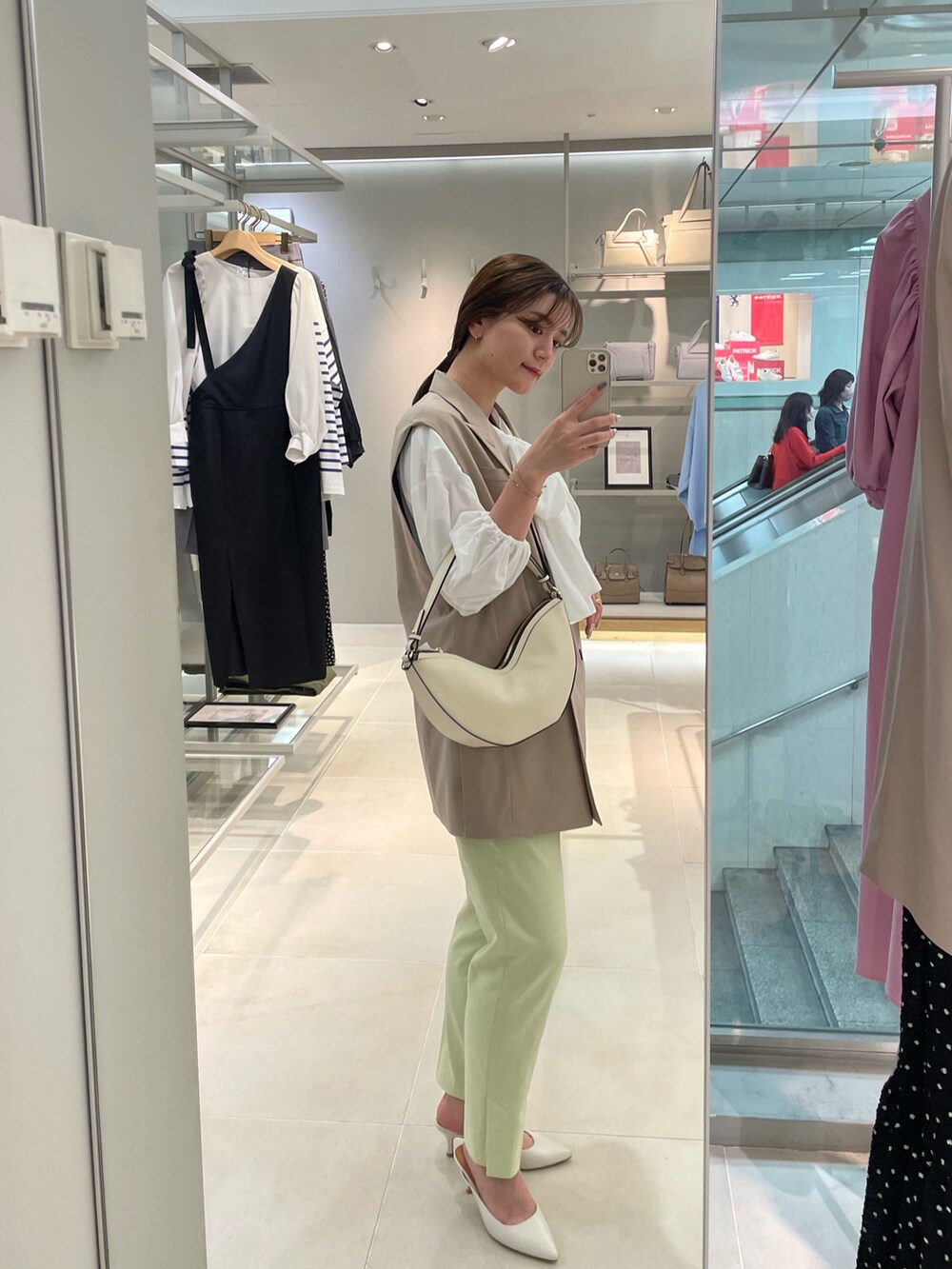 ベージュ系のベスト、ホワイト系のシャツ/ブラウス、グリーン系のその他パンツを着用したレディースの春コーディネートの2枚目の写真