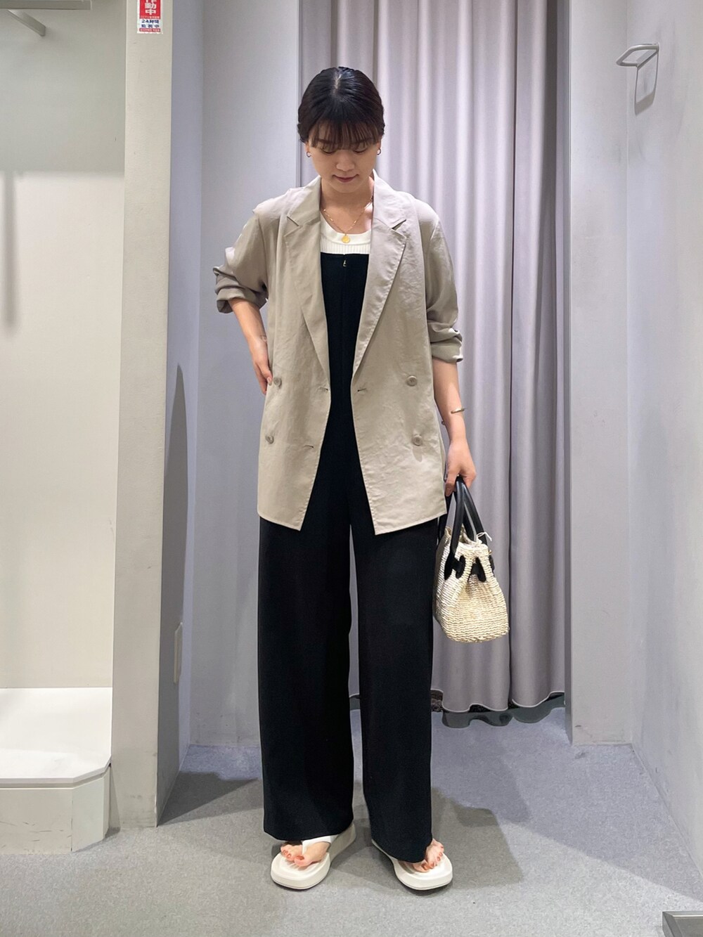 ベージュ系のテーラードジャケット、ホワイト系のタンクトップ、ブラック系のサロペット/オーバーオールを着用したレディースの夏コーディネートの2枚目の写真