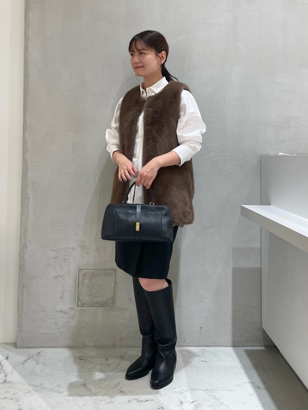 ブラウン系のジャケット/アウター、ホワイト系のシャツ/ブラウス、ブラック系のワンピースを着用したレディースの秋コーディネートの2枚目の写真