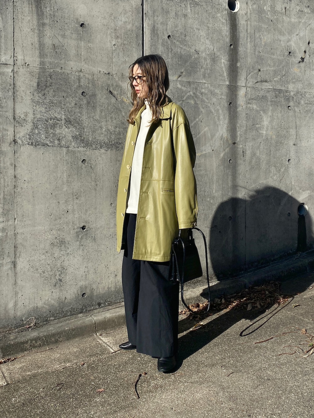 グリーン系のテーラードジャケット、ホワイト系のスウェット、ブラック系のスラックスを着用したレディースの冬コーディネートの3枚目の写真