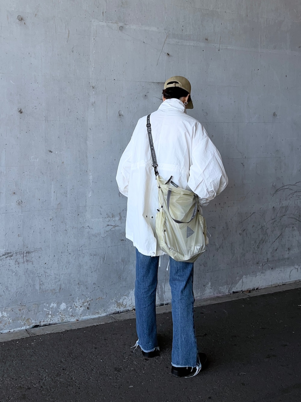 ホワイト系のマウンテンパーカー、ホワイト系のトートバッグ、ブラック系のその他シューズを着用したレディースの春コーディネートの3枚目の写真