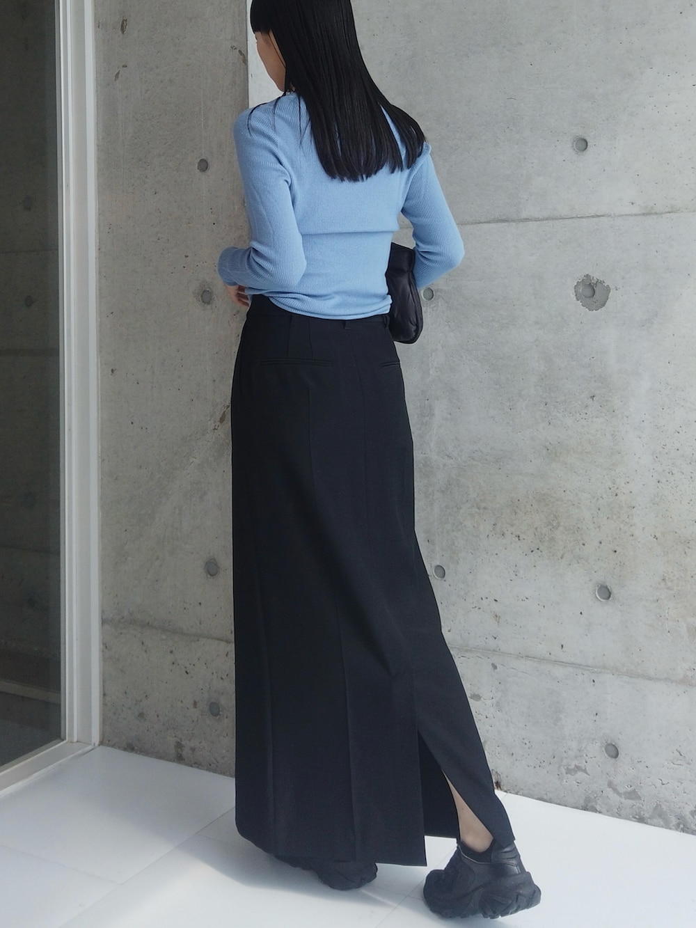 ブラック系のスカート、ブラック系のハンドバッグ、ブラック系のスニーカーを着用したレディースの秋コーディネートの3枚目の写真