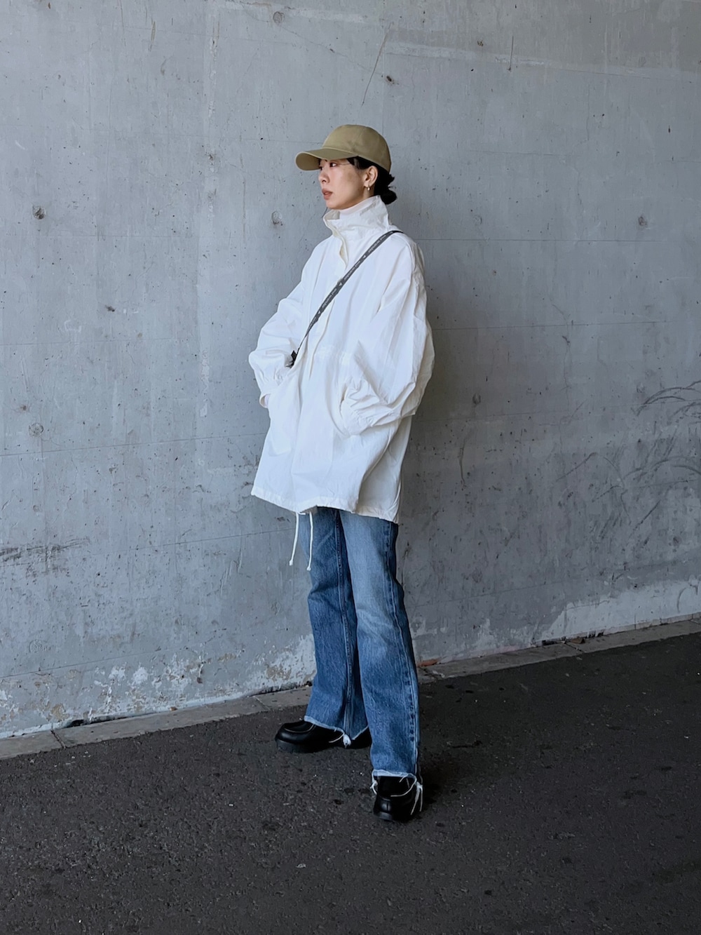 ホワイト系のマウンテンパーカー、ホワイト系のトートバッグ、ブラック系のその他シューズを着用したレディースの春コーディネートの2枚目の写真