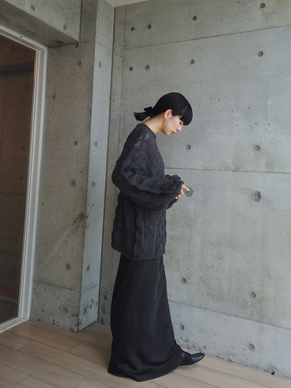 グレー系のニット/セーター、ブラック系のスカート、シルバー系のピアス（両耳用）を着用したレディースの秋コーディネートの4枚目の写真