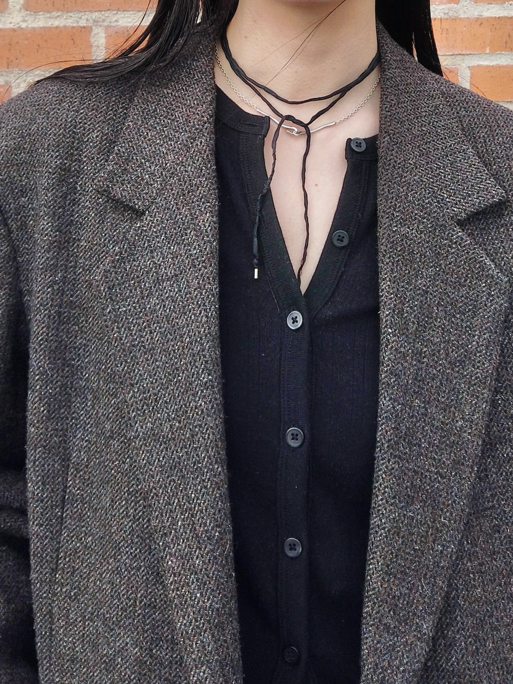 ブルー系のデニムパンツ、ブラック系のカーディガン/ボレロ、ブラウン系のテーラードジャケットを着用したレディースの春コーディネートの3枚目の写真