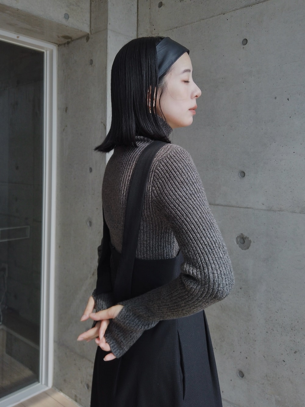 ブラック系のワンピース、グレー系のニット/セーター、ブラック系のモカシン/デッキシューズを着用したレディースの秋コーディネートの2枚目の写真