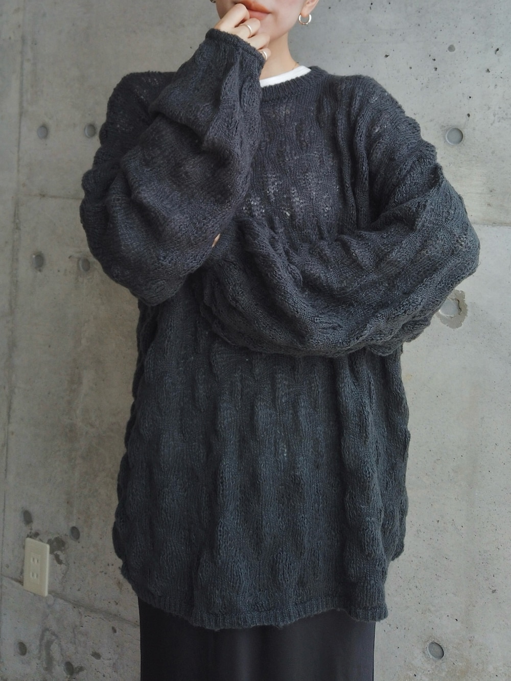 グレー系のニット/セーター、ブラック系のスカート、シルバー系のピアス（両耳用）を着用したレディースの秋コーディネートの2枚目の写真