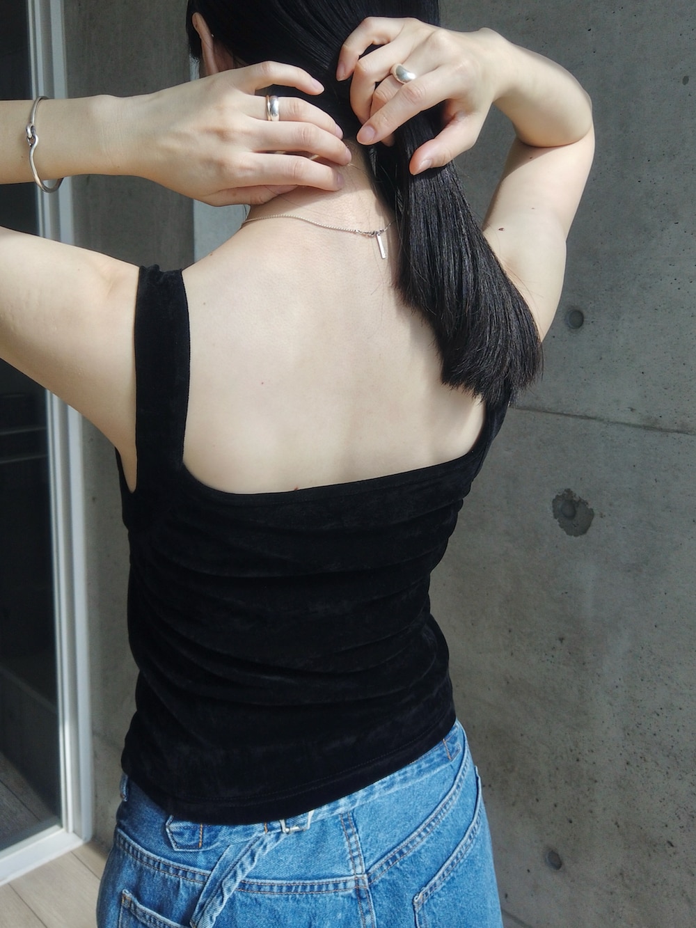 ブルー系のデニムパンツ、ブラック系のショルダーバッグ、ブラック系のブーツを着用したレディースの春コーディネートの4枚目の写真