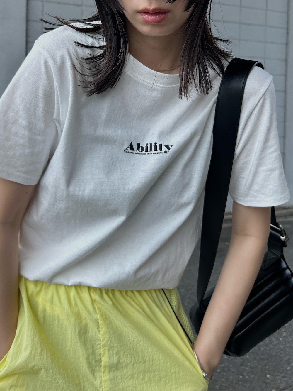 グリーン系のTシャツ/カットソー、シルバー系のショルダーバッグ、ブラック系のその他シューズを着用したレディースの夏コーディネートの2枚目の写真