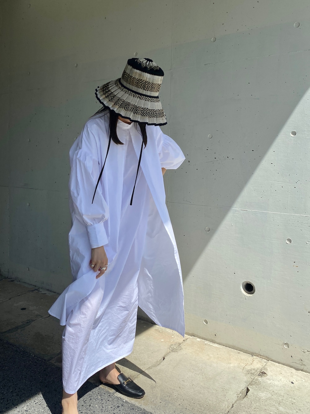 ブラック系のその他シューズ、ホワイト系のワンピース、ブラック系のハットを着用したレディースの夏コーディネートの3枚目の写真