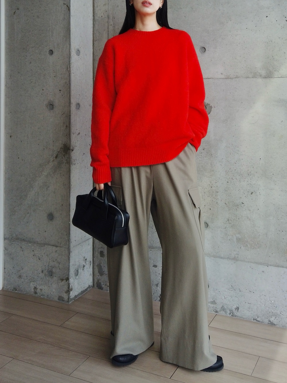 ブラック系のハンドバッグ、グリーン系のカーゴパンツ、ブラック系のモカシン/デッキシューズを着用したレディースの冬コーディネートの3枚目の写真