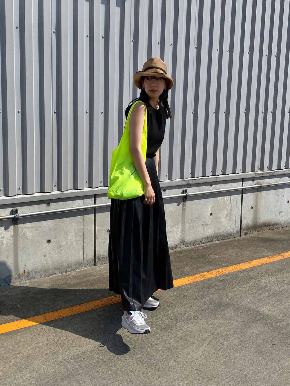 ブラック系のタンクトップ、ブラック系のスカート、ホワイト系のスニーカーを着用したレディースの夏コーディネートの2枚目の写真