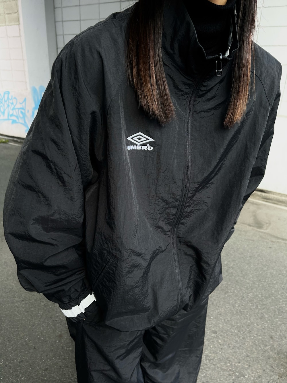 ブラック系のその他アウター、ブラック系のその他パンツ、ブラック系のスニーカーを着用したレディースの冬コーディネートの2枚目の写真