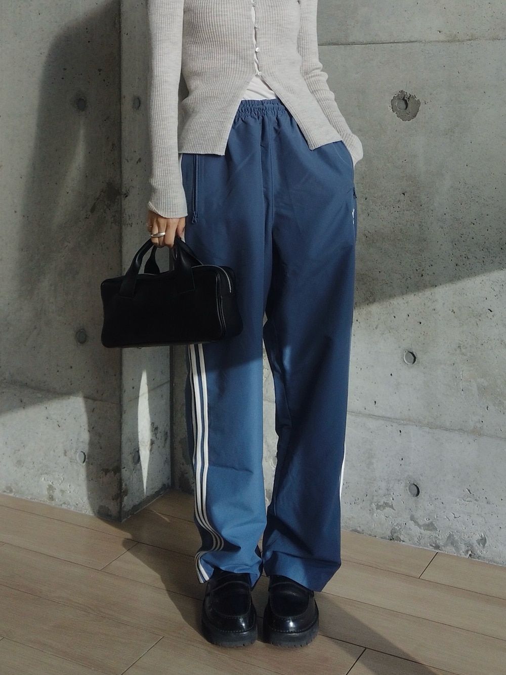 グレー系のカーディガン/ボレロ、ブルー系のその他パンツ、ブラック系のハンドバッグを着用したレディースの冬コーディネートの3枚目の写真