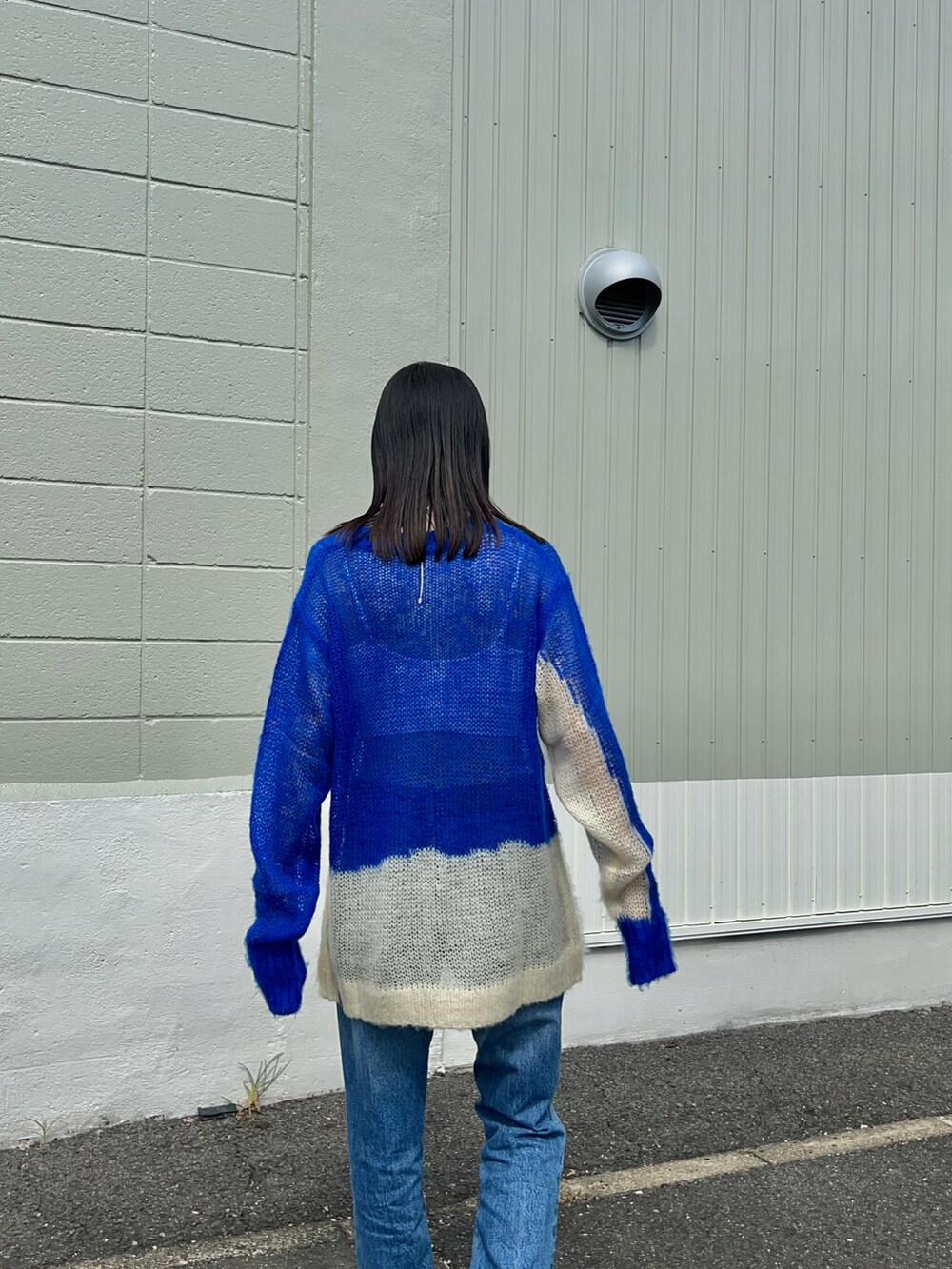 ブルー系のニット/セーター、ブルー系のデニムパンツ、ベージュ系のファンデーションを着用したレディースの秋コーディネートの3枚目の写真