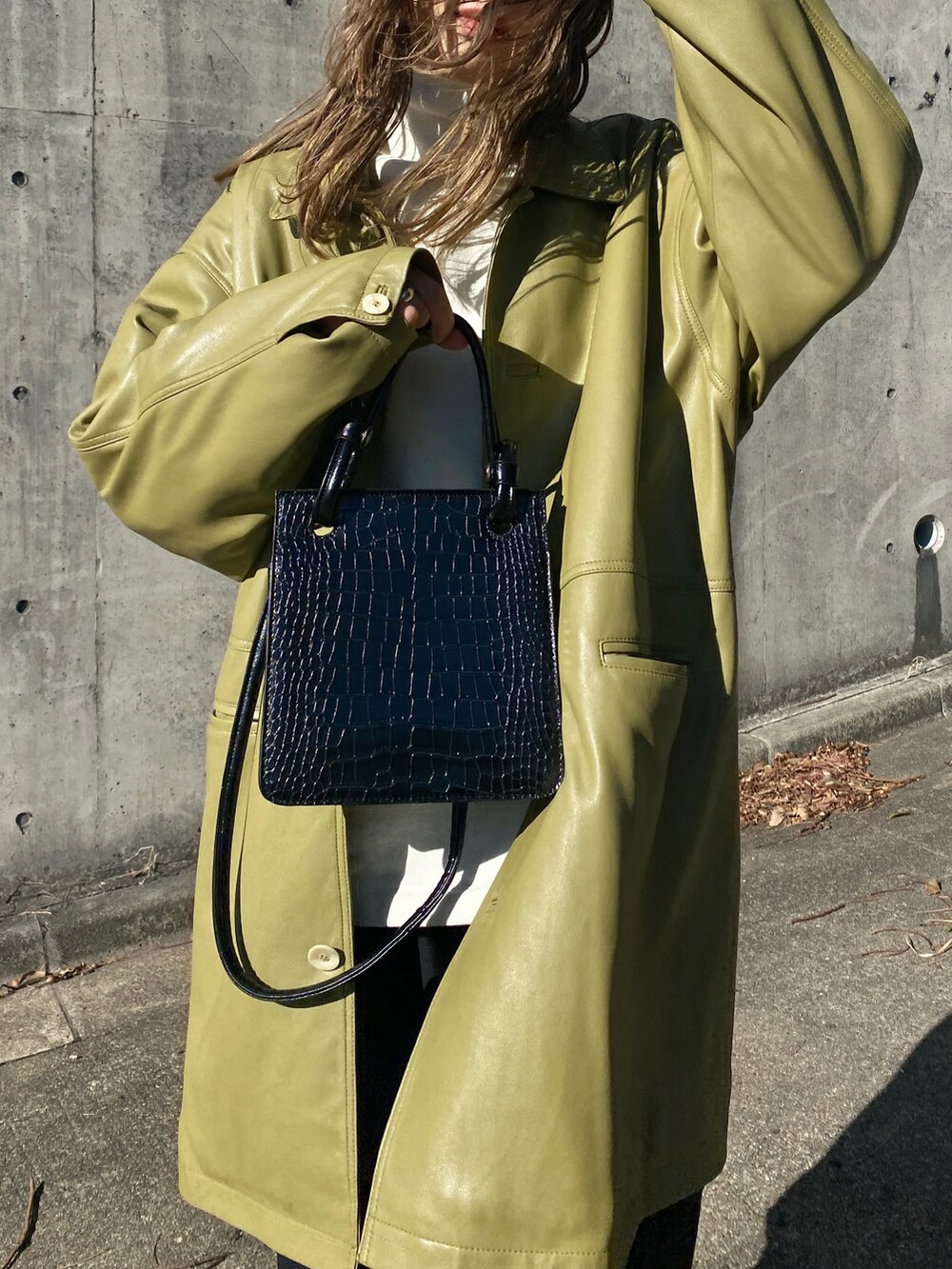 グリーン系のテーラードジャケット、ホワイト系のスウェット、ブラック系のスラックスを着用したレディースの冬コーディネートの2枚目の写真