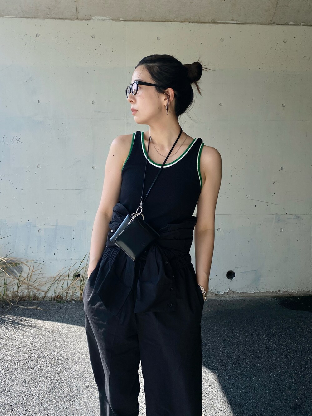 ブラック系のつなぎ/オールインワン、ブラック系のタンクトップ、ブラック系のブーツを着用したレディースの春コーディネートの3枚目の写真
