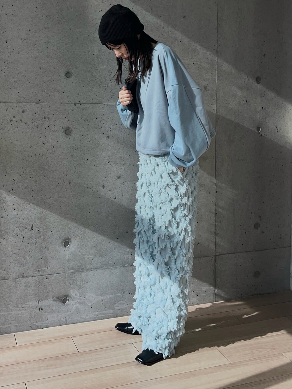 ブルー系のスウェット、ブルー系のパンツ、ブラック系のショルダーバッグを着用したレディースの秋コーディネートの3枚目の写真