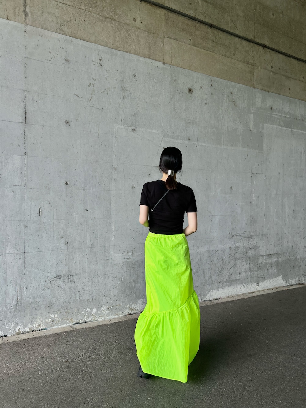 イエロー系のスカート、ブラック系のシューズ、ブラック系のスマホケース/カバーを着用したレディースの夏コーディネートの2枚目の写真