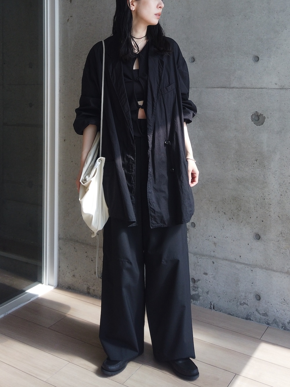 ブラック系のジャケット/アウター、ブラック系のその他パンツ、ブラック系のモカシン/デッキシューズを着用したレディースの春コーディネートの2枚目の写真