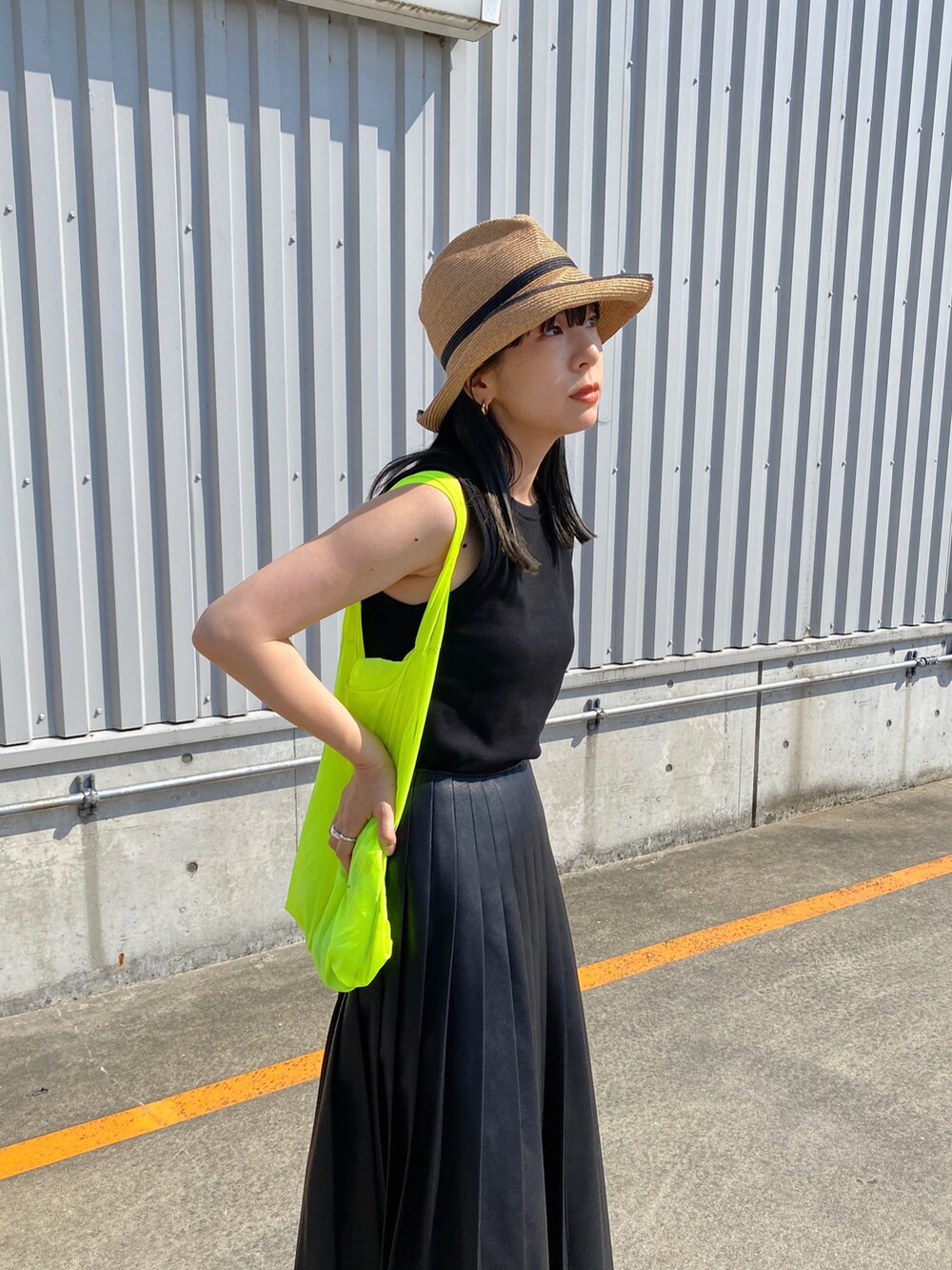 ブラック系のタンクトップ、ブラック系のスカート、ホワイト系のスニーカーを着用したレディースの夏コーディネートの5枚目の写真