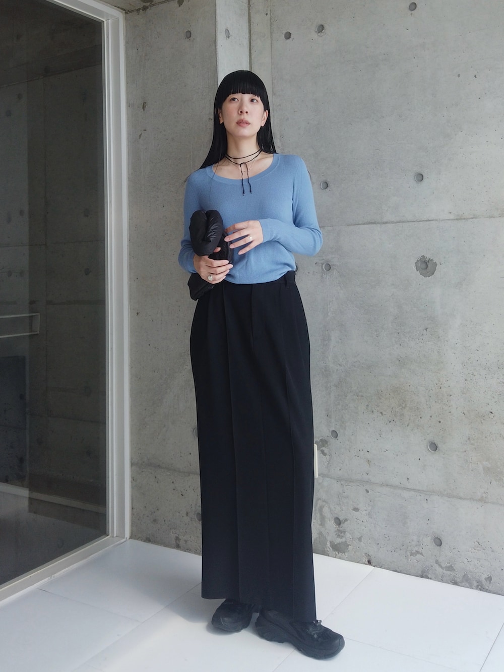 ブラック系のスカート、ブラック系のハンドバッグ、ブラック系のスニーカーを着用したレディースの秋コーディネートの2枚目の写真