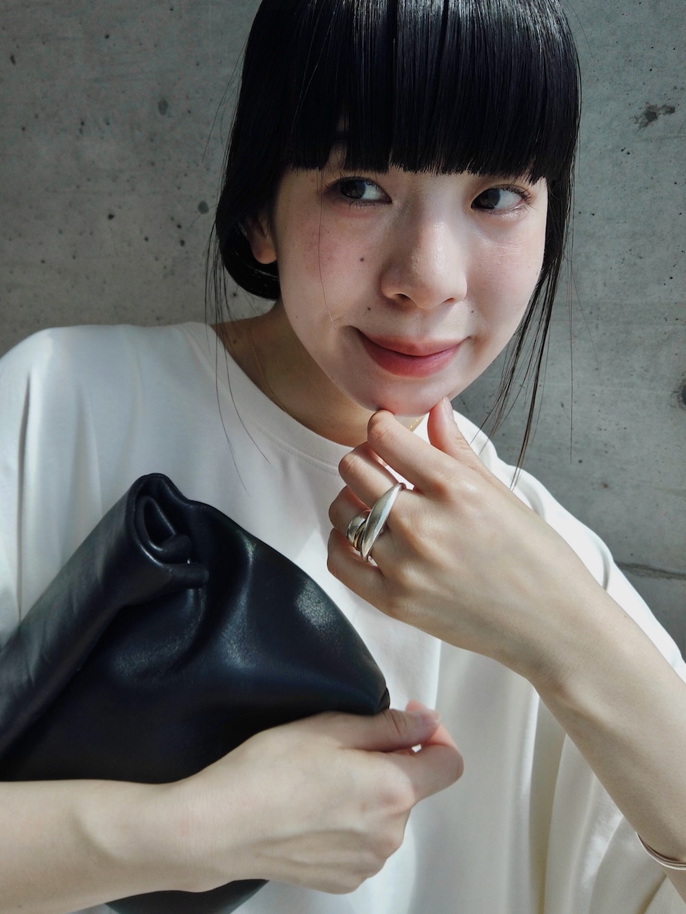 ホワイト系のスカート、ホワイト系のTシャツ/カットソー、ブラック系のショルダーバッグを着用したレディースの春コーディネートの2枚目の写真