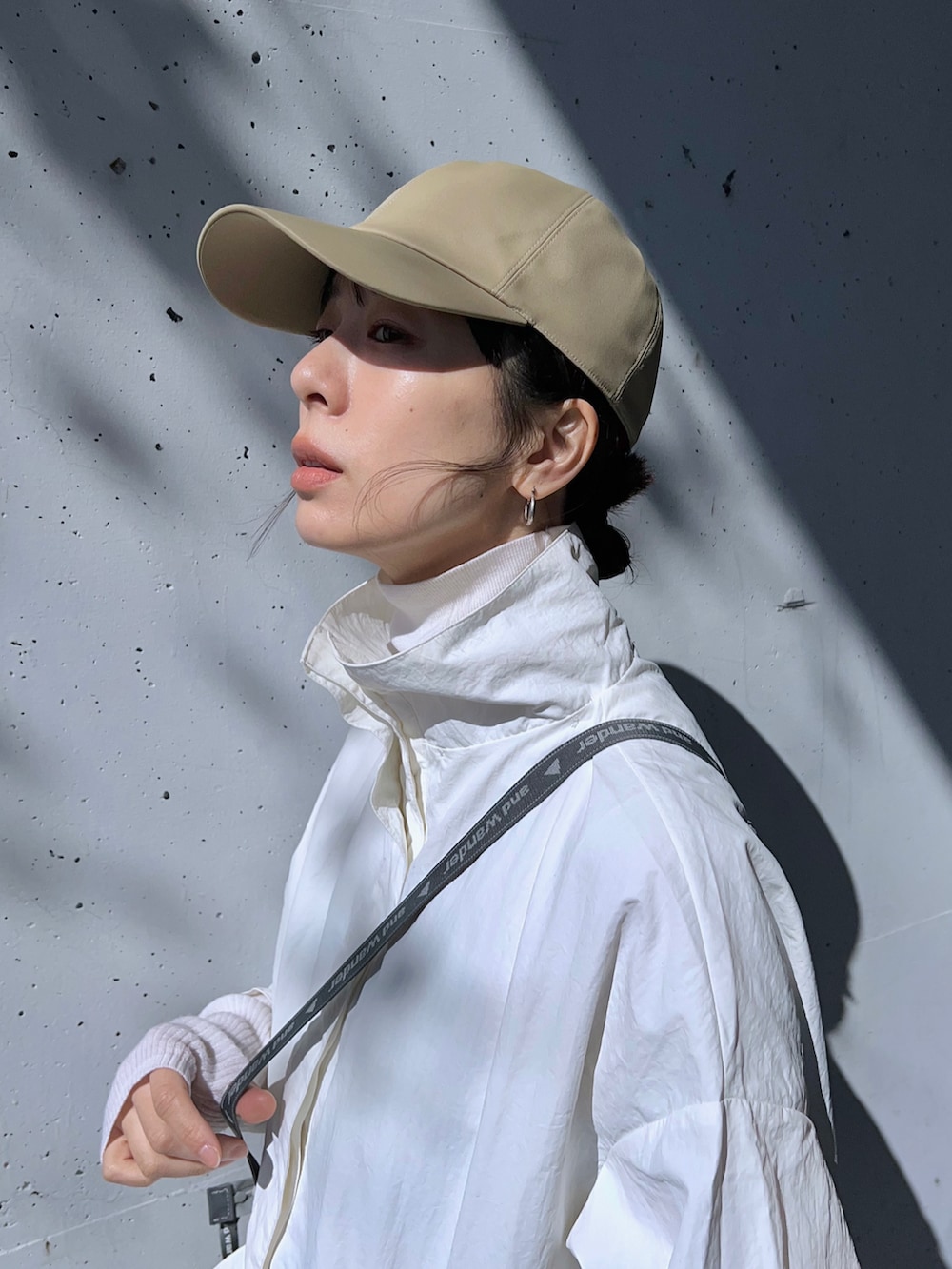 ホワイト系のマウンテンパーカー、ホワイト系のトートバッグ、ブラック系のその他シューズを着用したレディースの春コーディネートの4枚目の写真