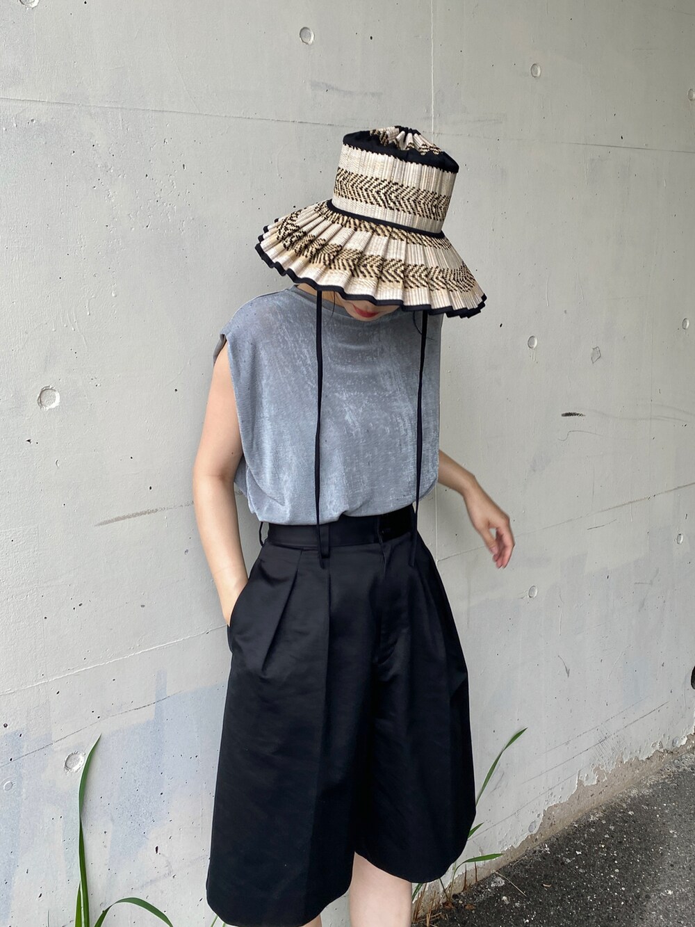 グレー系のTシャツ/カットソー、ブラック系のその他パンツ、ブラック系のハットを着用したレディースの夏コーディネートの3枚目の写真