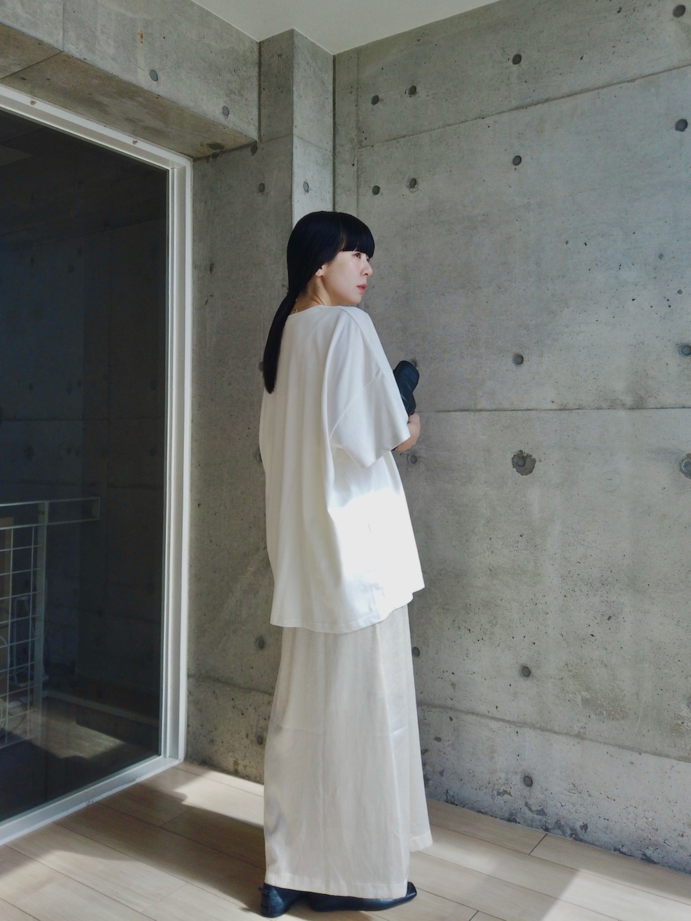 ホワイト系のスカート、ホワイト系のTシャツ/カットソー、ブラック系のショルダーバッグを着用したレディースの春コーディネートの3枚目の写真