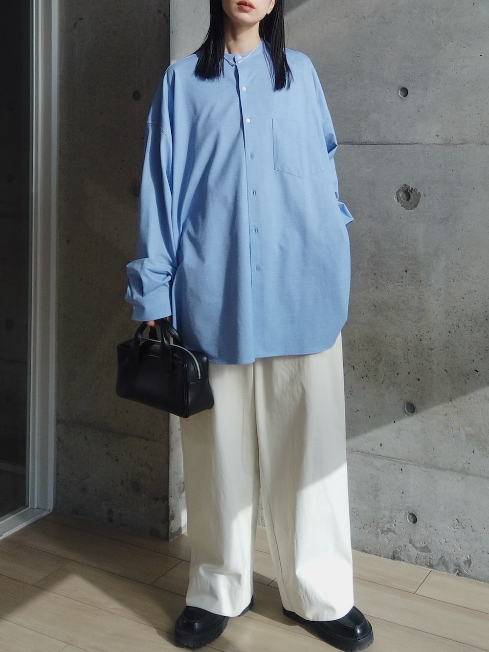 ブルー系のシャツ/ブラウス、ホワイト系のその他パンツ、ブラック系のハンドバッグを着用したレディースの春コーディネートの2枚目の写真