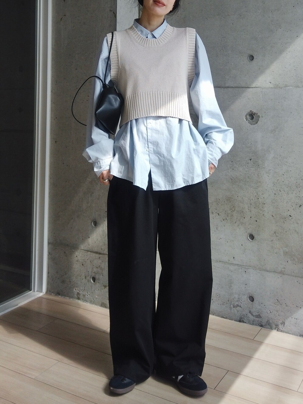 ホワイト系のベスト、ブルー系のシャツ/ブラウス、ブラック系のその他パンツを着用したレディースの春コーディネートの2枚目の写真