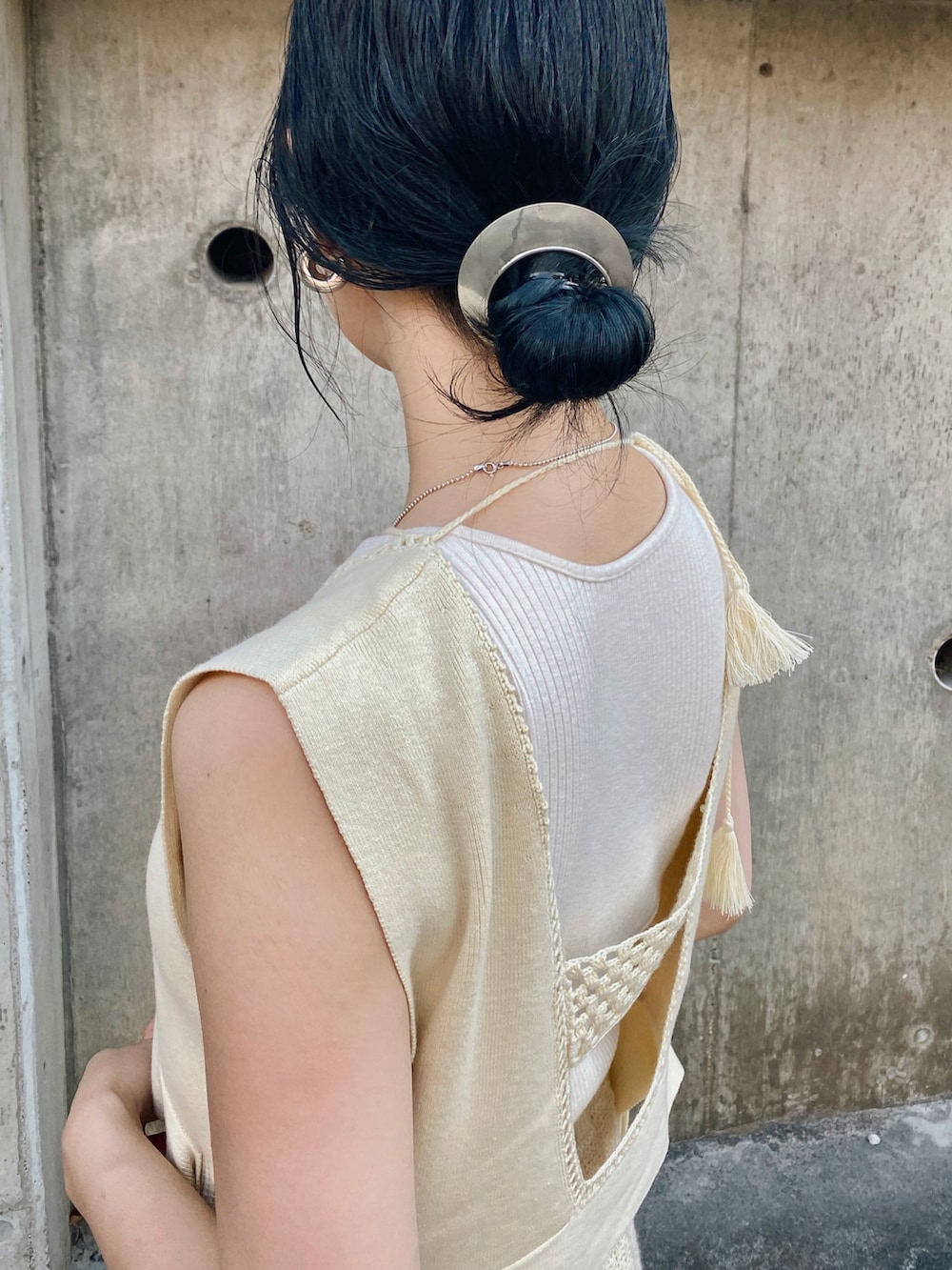 ホワイト系のニット/セーター、ホワイト系のサンダルを着用したレディースの夏コーディネートの5枚目の写真