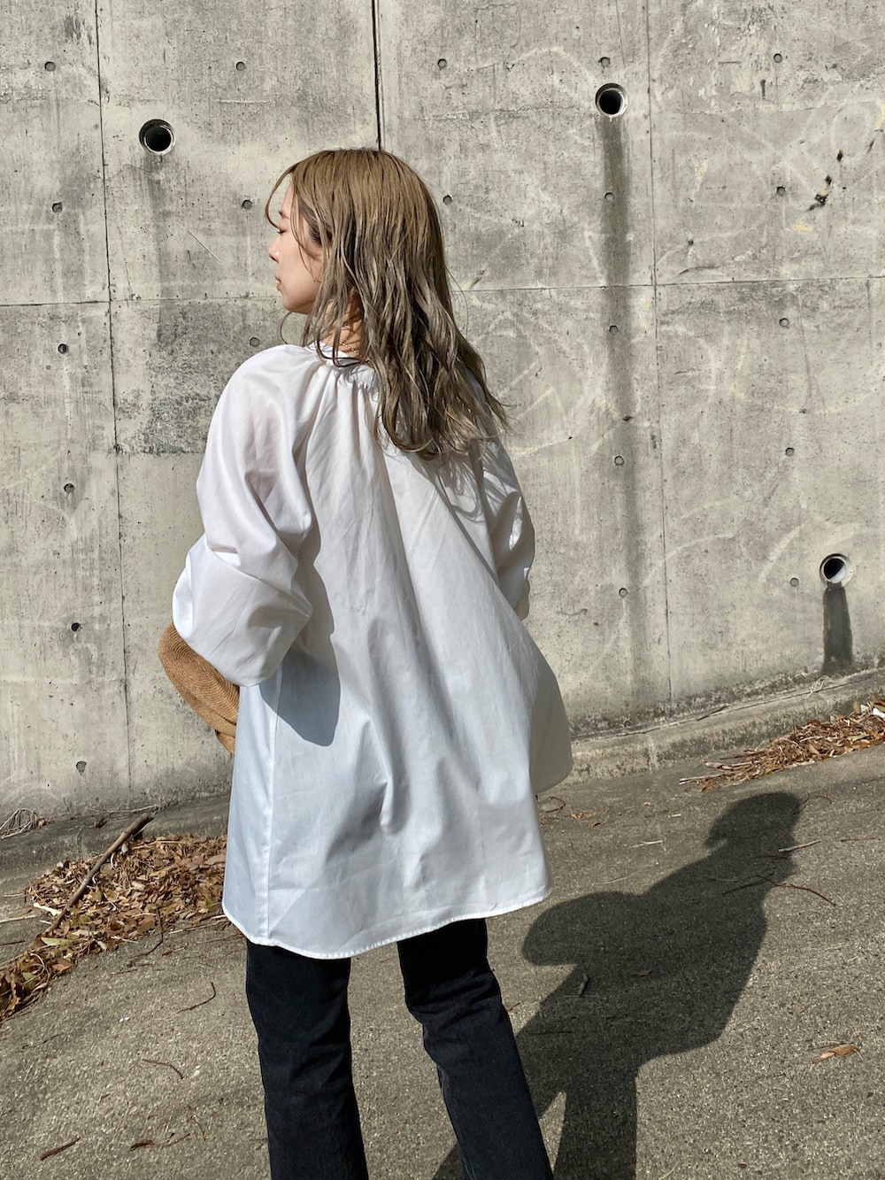 ブラック系のデニムパンツ、グリーン系のサンダル、ホワイト系のシャツ/ブラウスを着用したレディースの春コーディネートの5枚目の写真