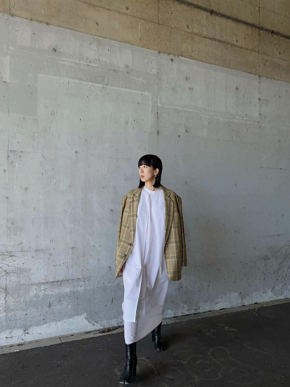 イエロー系のテーラードジャケット、ホワイト系のワンピースを着用したレディースの冬コーディネートの5枚目の写真