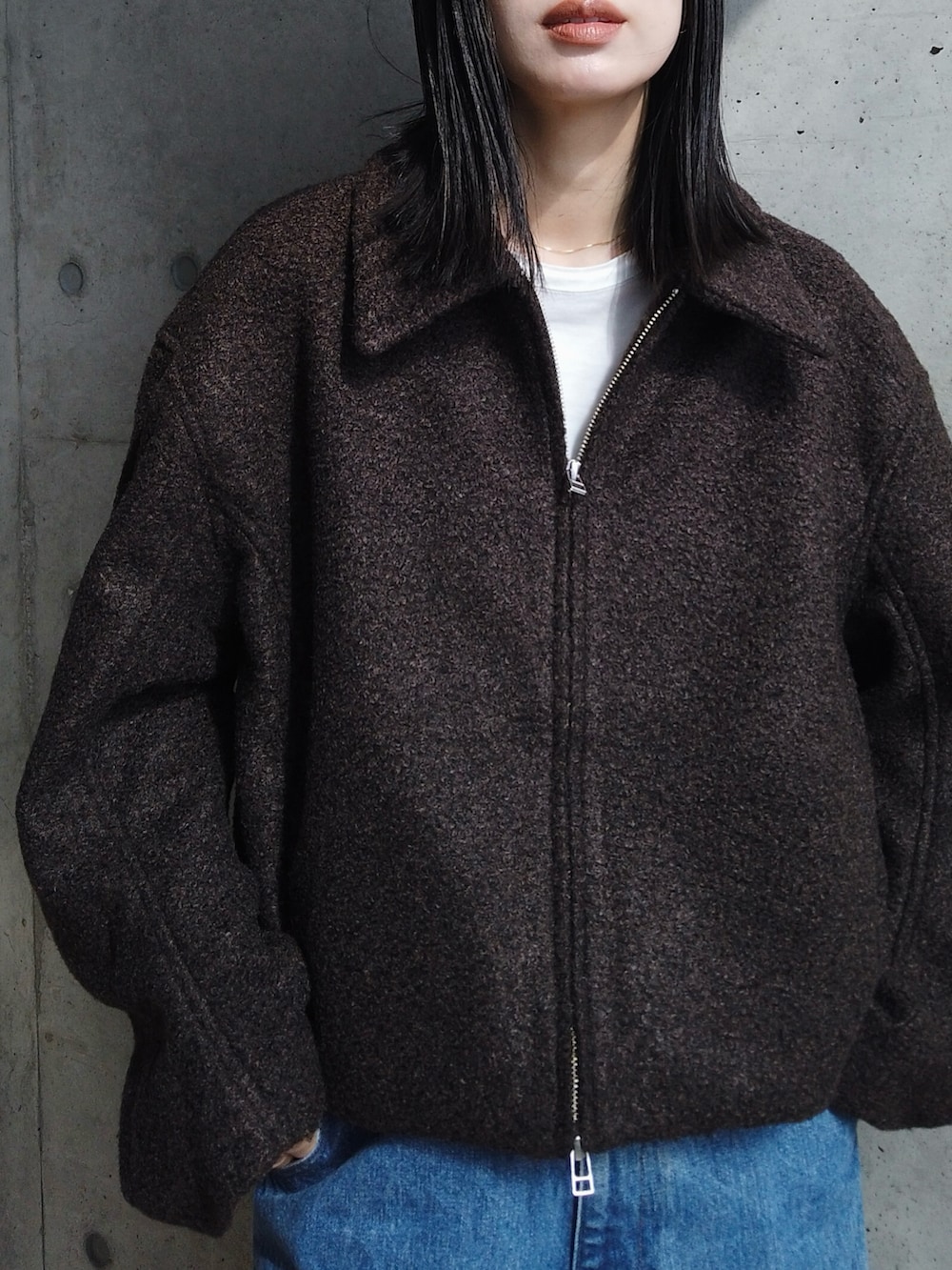 ブラック系のTシャツ/カットソー、ブルー系のデニムパンツ、ブラック系のスニーカーを着用したレディースの秋コーディネートの2枚目の写真