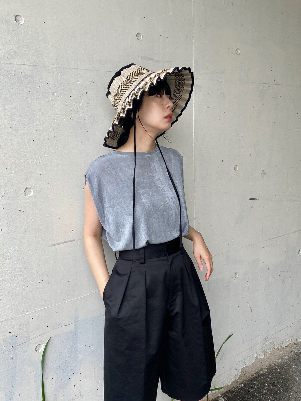 グレー系のTシャツ/カットソー、ブラック系のその他パンツ、ブラック系のハットを着用したレディースの夏コーディネートの2枚目の写真